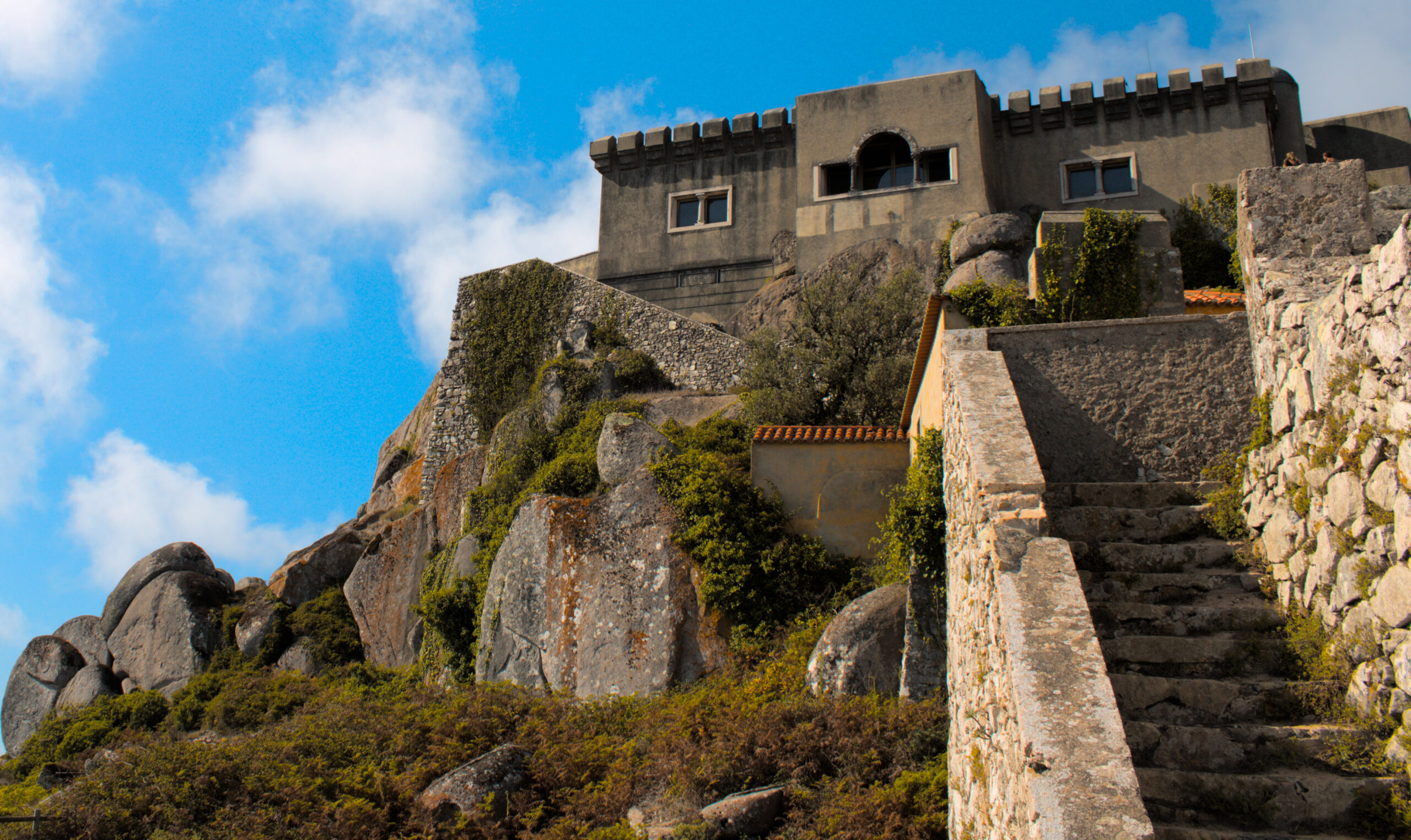 Escadaria em pedra conduzindo à Capela de Nossa Senhora da Peninha — cenário místico sobre a Serra de Sintra